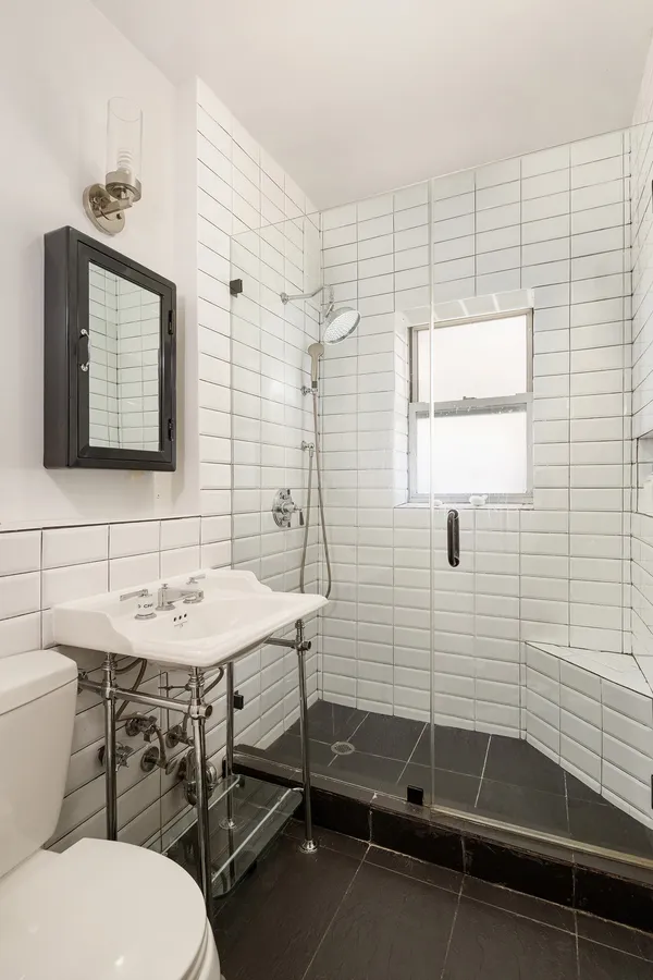 a bathroom with a sink a toilet and shower