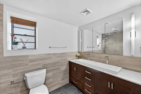 a bathroom with a toilet sink and mirror