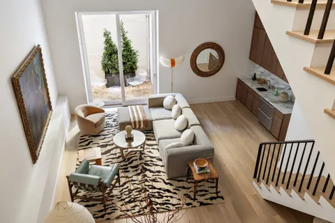 a living room with furniture a rug and a window