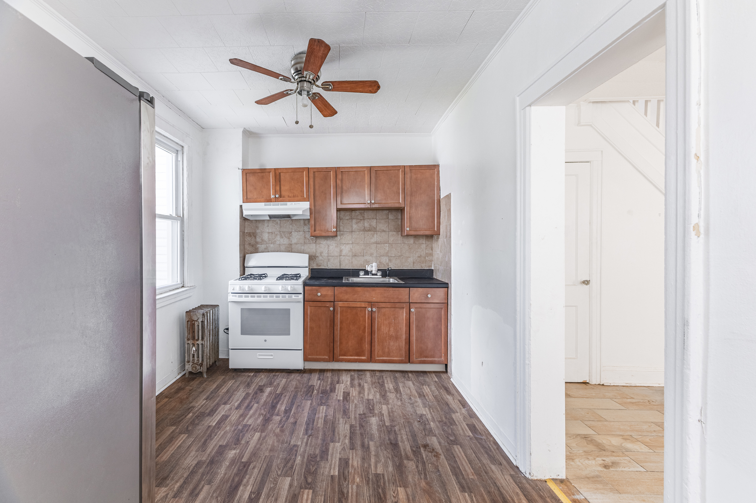 69-29 67th Place Queens, NY 11385 - Photo 11 of 24 a kitchen with a refrigerator and white cabinets