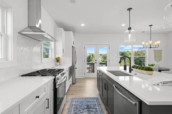 a kitchen with stainless steel appliances a sink stove and cabinets