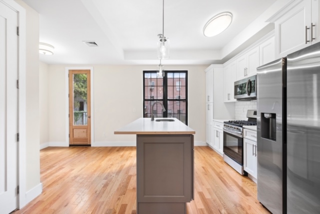 14 Pilling Street Brooklyn, NY 11207 - Photo 3 of 14 a kitchen with kitchen island a counter top space a sink and stainless steel appliances