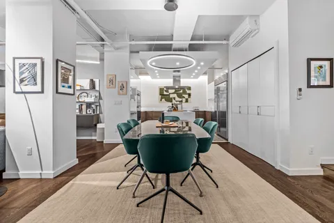 a room with stainless steel appliances furniture and a chandelier