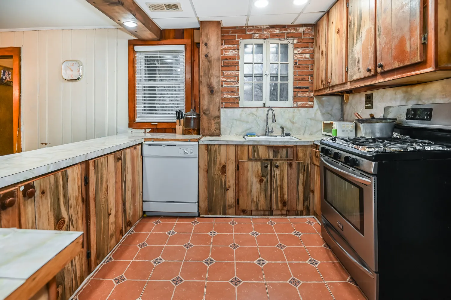 a kitchen with stainless steel appliances a stove a sink and a microwave
