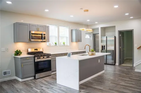 a kitchen with stainless steel appliances granite countertop a stove top oven and sink