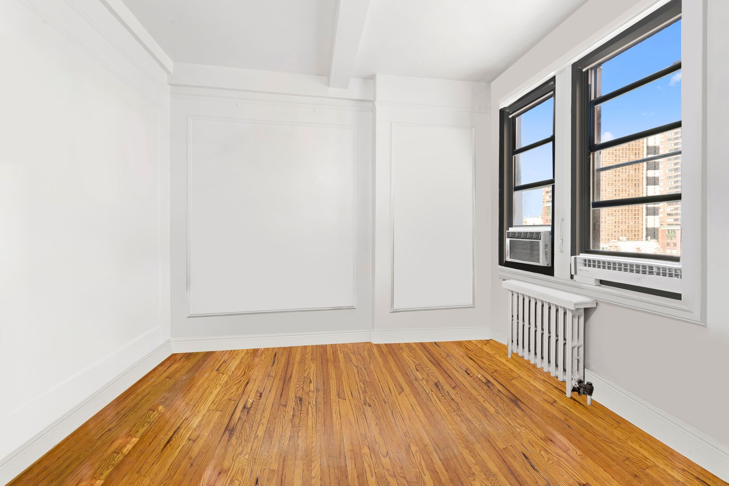 457 West 57th Street, Unit 1501 Manhattan, NY 10019 - Photo 4 of 6 a view of an empty room with wooden floor and a window