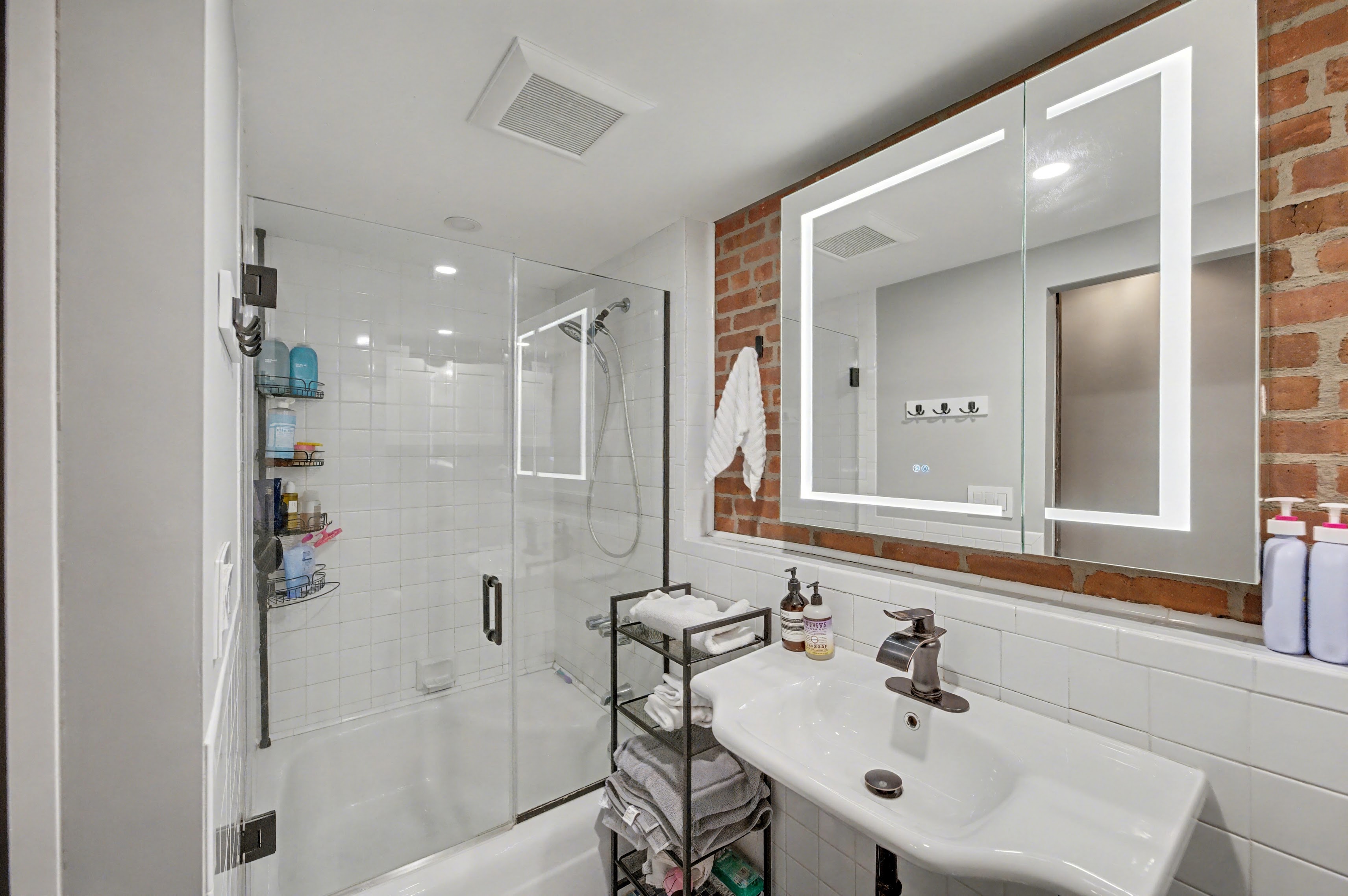 132 Joralemon Street, Unit 2C Brooklyn, NY 11201 - Photo 8 of 12 a bathroom with a sink shower and a mirror