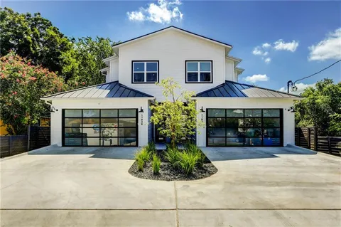 a view of a house with a yard and potted plants