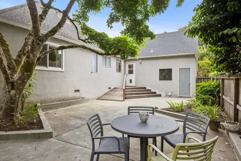a backyard of a house with table and chairs