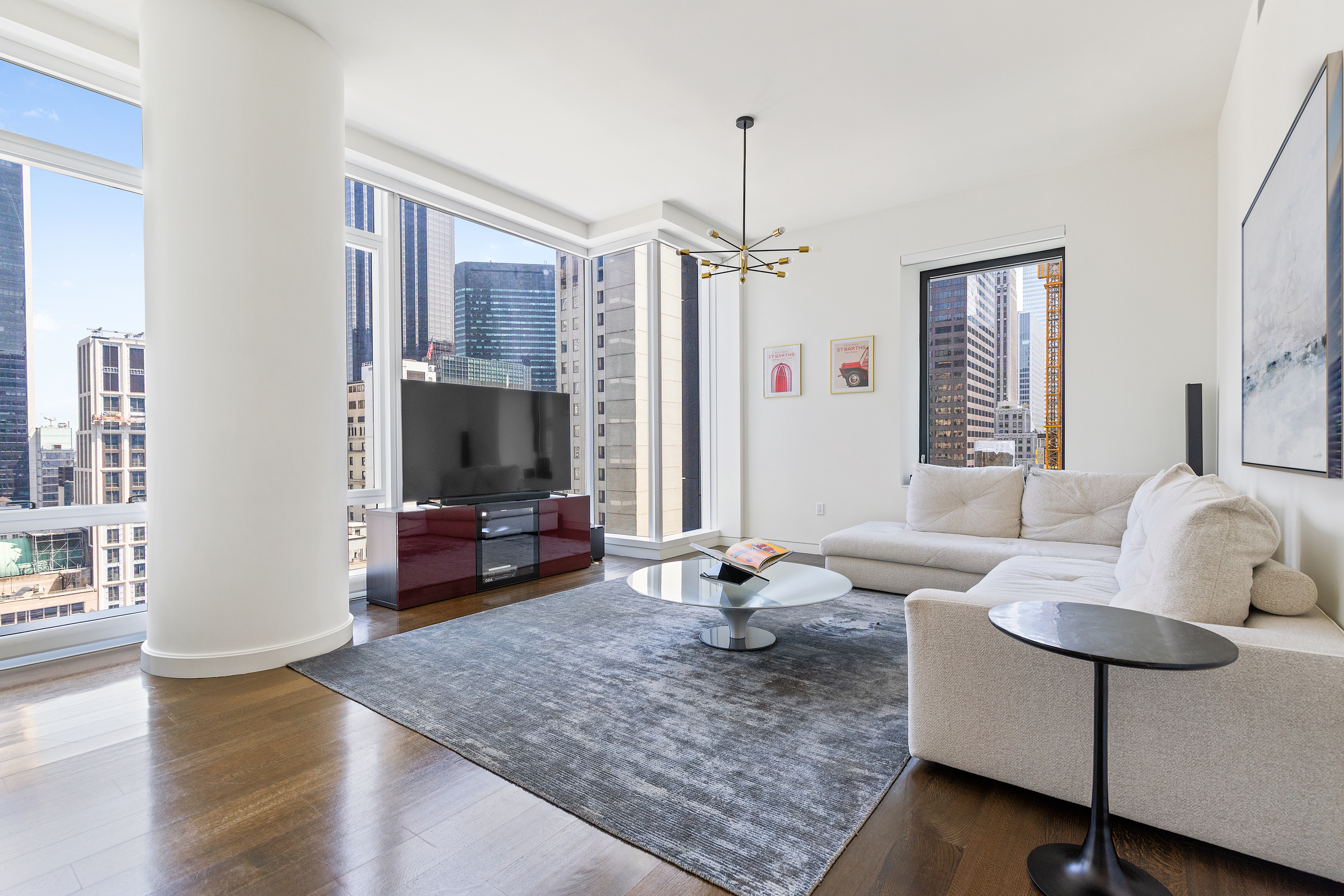 20 West 53rd Street, Unit 22A Manhattan, NY 10019 - Photo 3 of 16 a living room with furniture and a flat screen tv