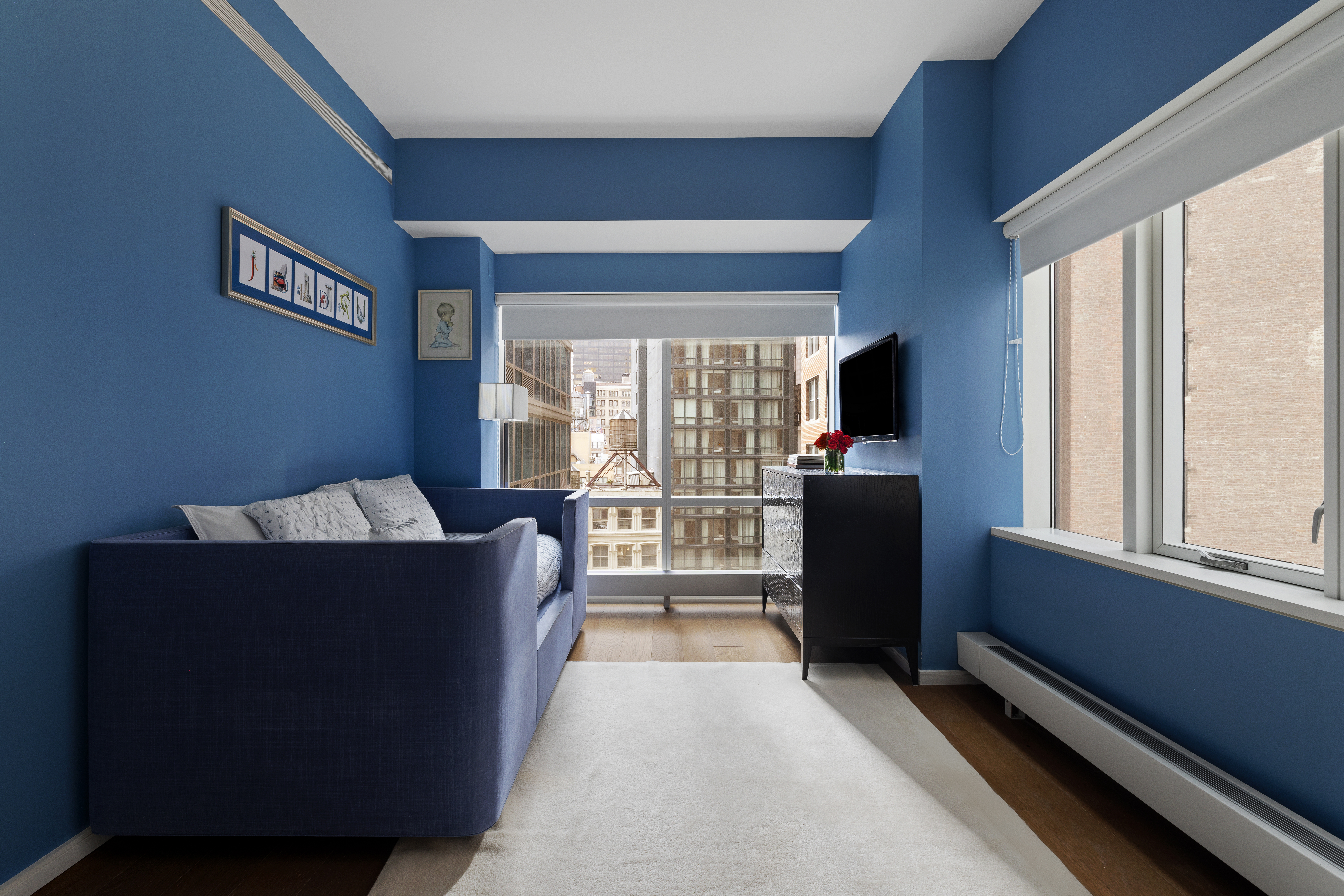 121 Nassau Street, Unit 17A Manhattan, NY 10038 - Photo 10 of 19 a living room with furniture and a flat screen tv