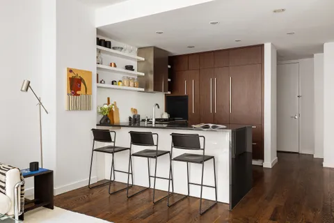 a kitchen with stainless steel appliances a stove a refrigerator and wooden floor