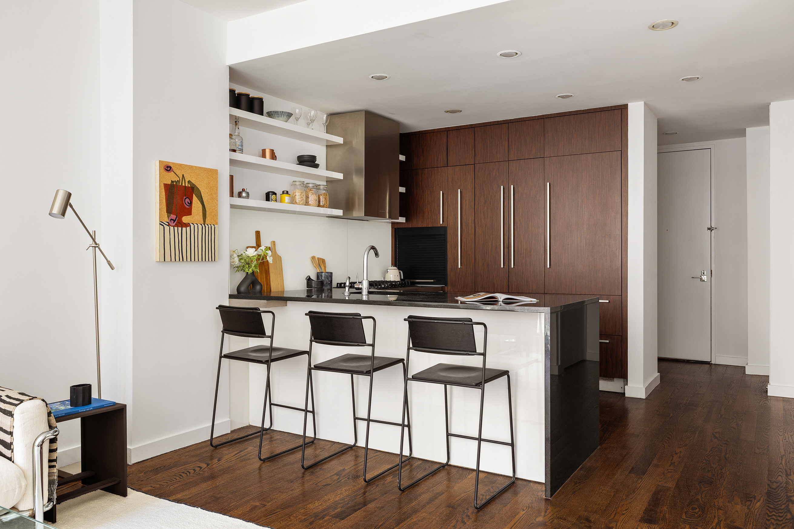 133 West 22nd Street, Unit 8C Manhattan, NY 10011 - Photo 3 of 11 a kitchen with stainless steel appliances a stove a refrigerator and wooden floor