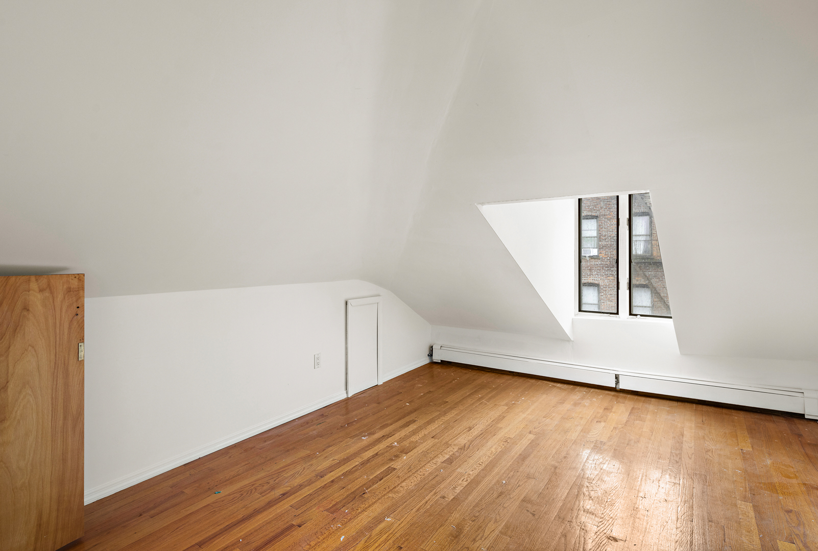 558 84th Street Brooklyn, NY 11209 - Photo 21 of 25 a view of an empty room with wooden floor and a window