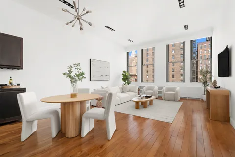 a living room with furniture a flat screen tv and a large window