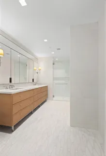 a bathroom with a double vanity sink a mirror and a bathtub