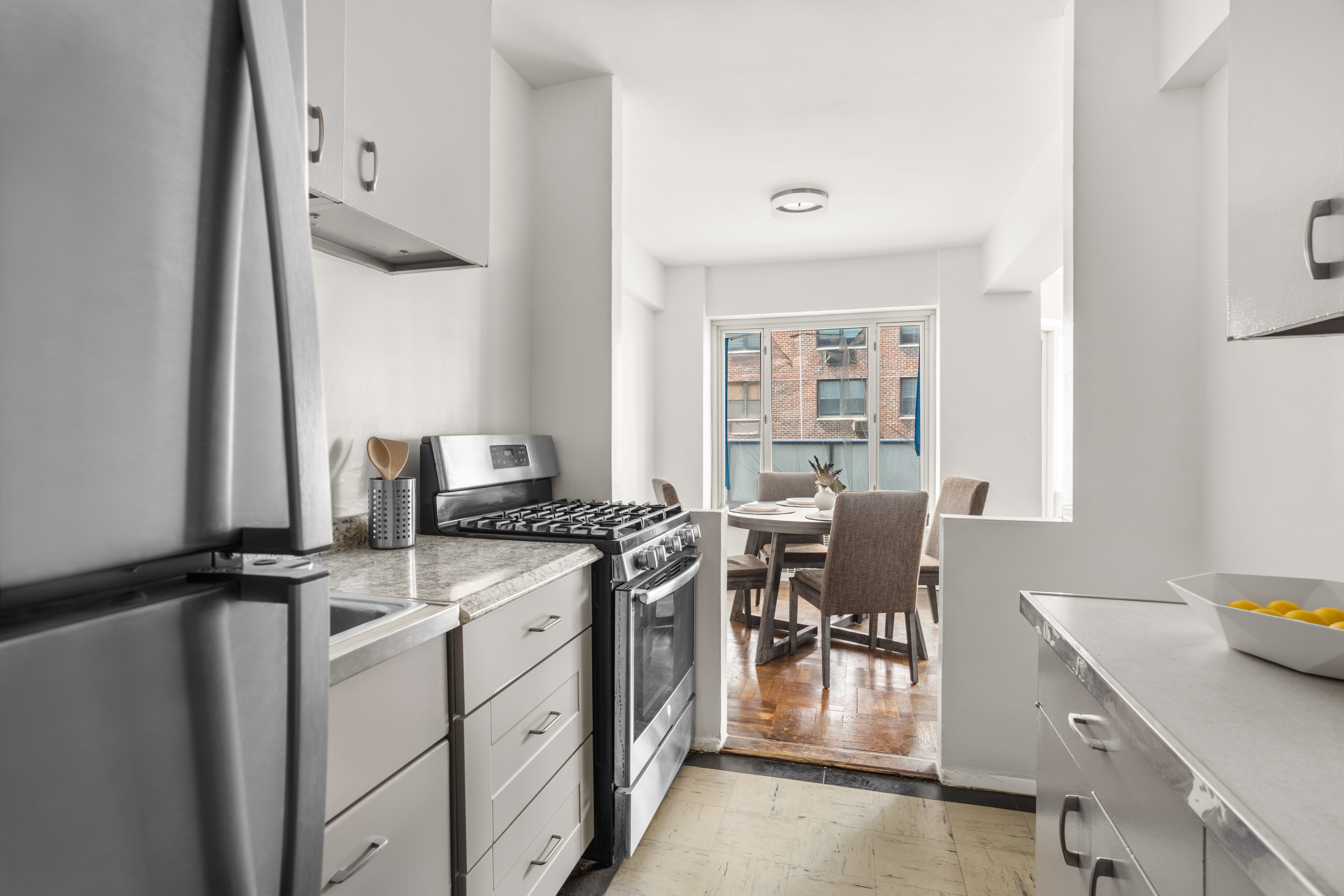 36 Sutton Place South, Unit 11D Manhattan, NY 10022 - Photo 4 of 11 a kitchen with a stove and a refrigerator