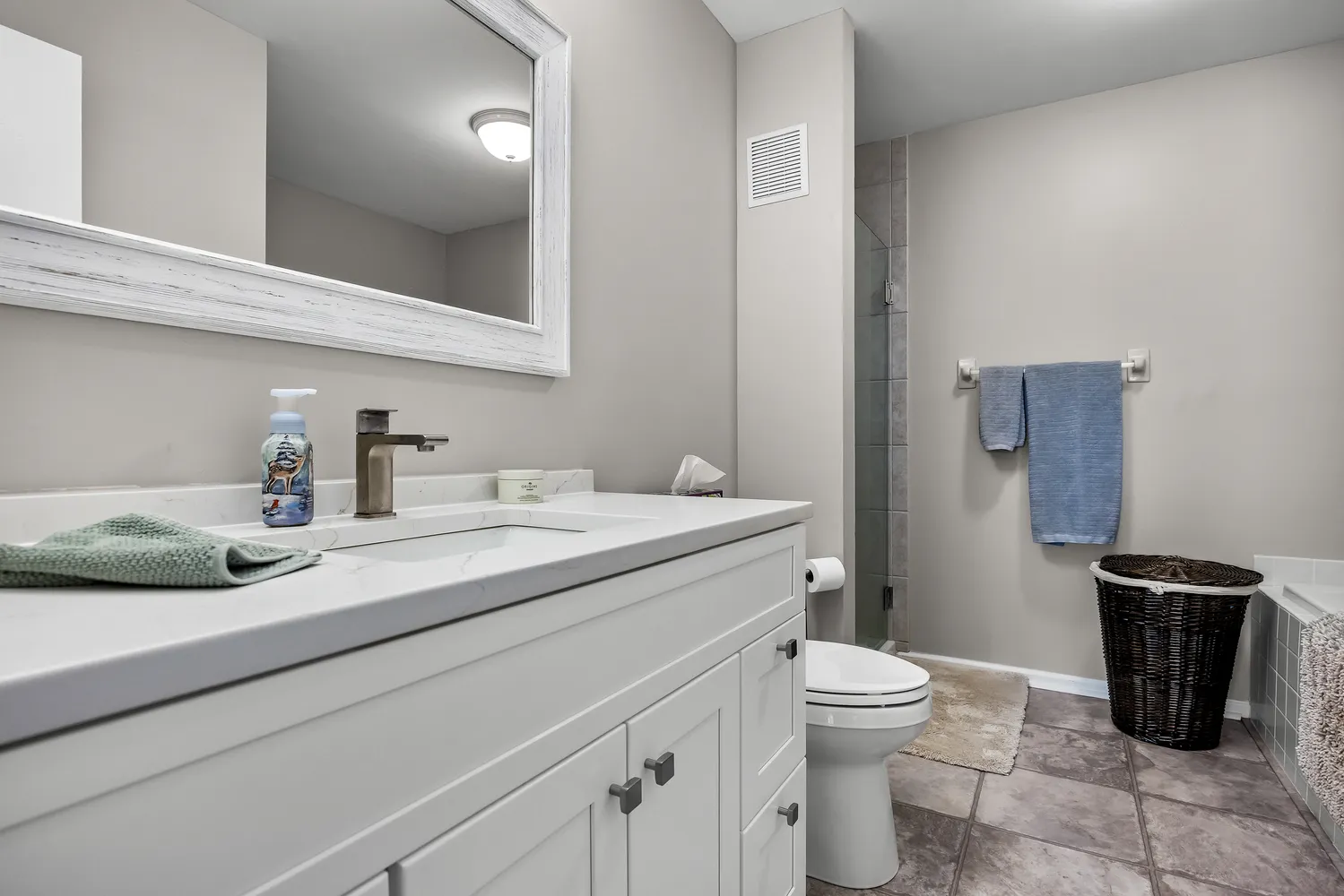 a bathroom with a granite countertop sink a toilet and a mirror