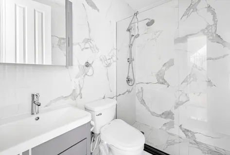 a white toilet sitting next to a bathroom sink