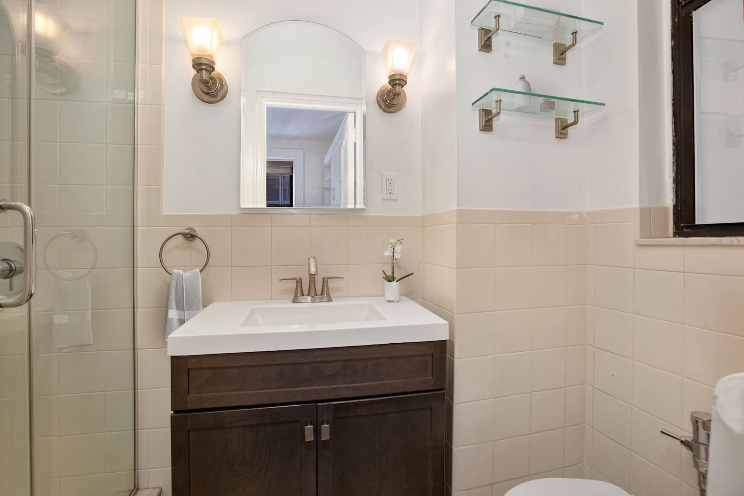 205 West 54th Street, Unit 2E Manhattan, NY 10019 - Photo 6 of 11 a bathroom with a sink a toilet and a mirror