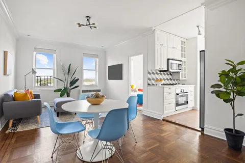 a living room with fireplace furniture and a potted plant