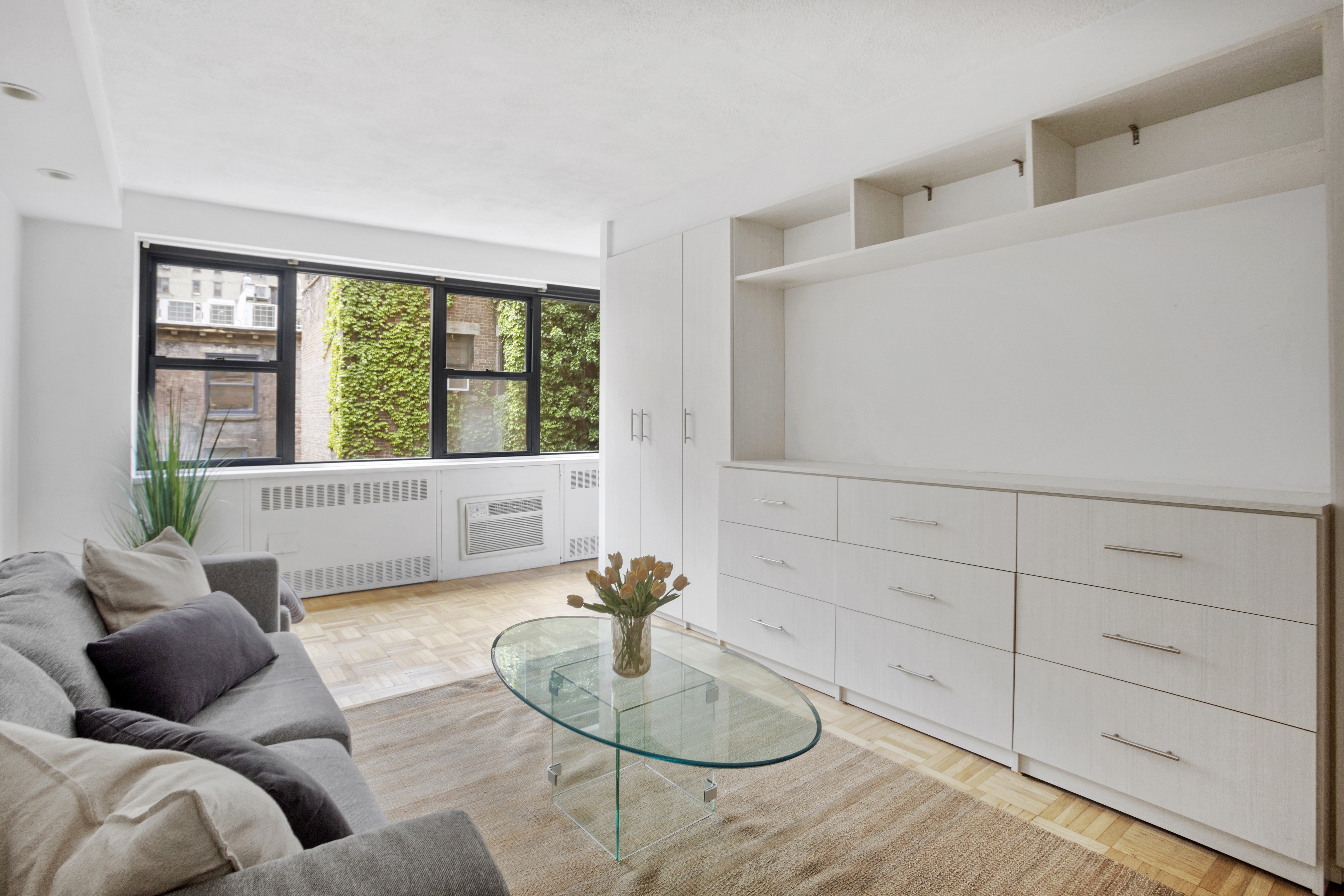 110 East 36th Street, Unit 4D Manhattan, NY 10016 - Photo 1 of 8 a living room with furniture and a potted plant