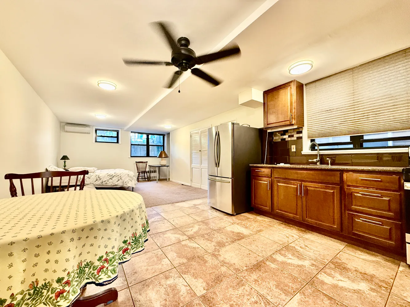 a large bedroom with a large bed a chandelier and dresser