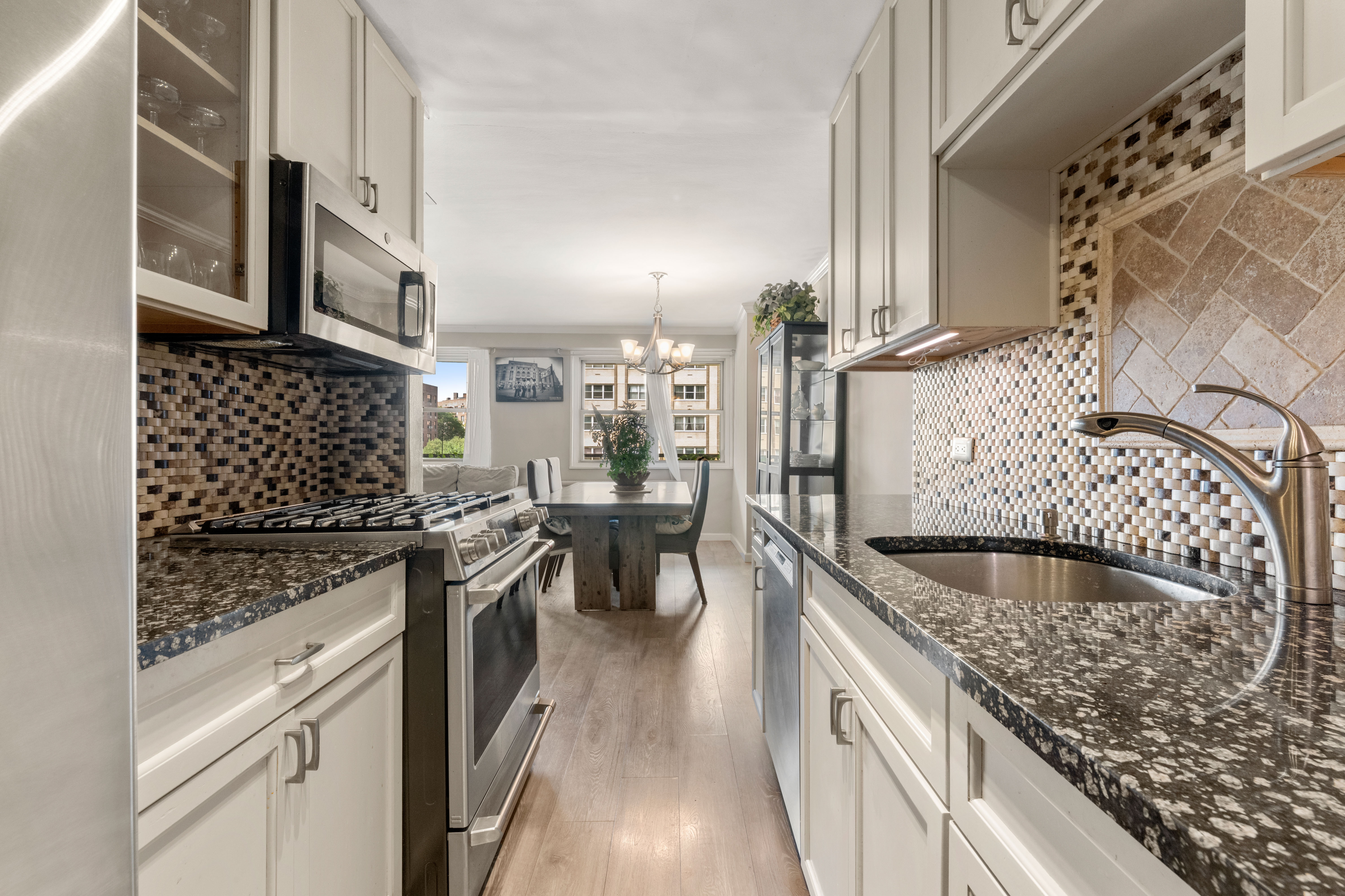 102-30 66th Road, Unit 7E Queens, NY 11375 - Photo 5 of 15 a kitchen with stainless steel appliances granite countertop a stove and a sink