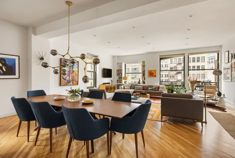 a view of a dining room and livingroom with lots of furniture wooden floor a chandelier