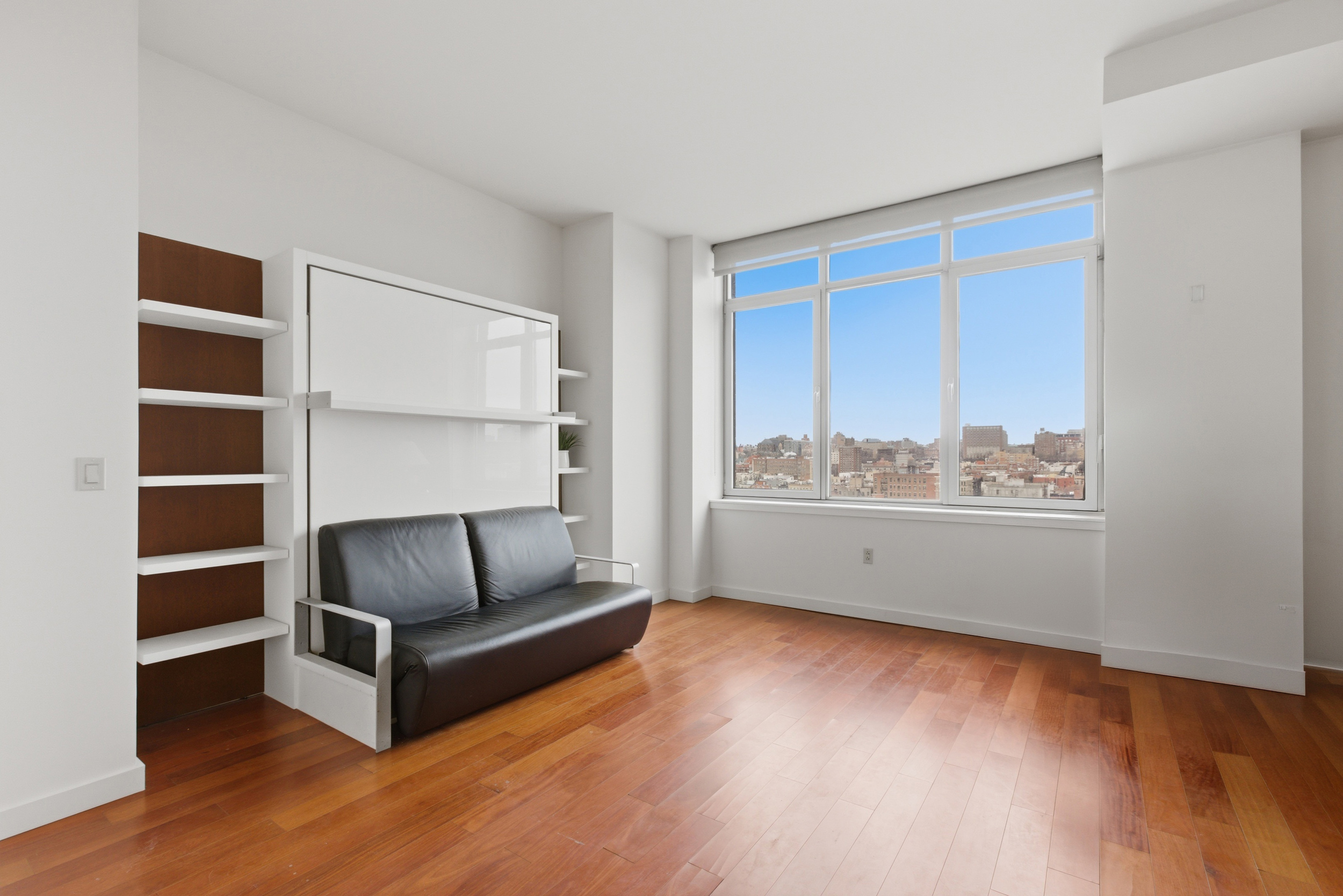 1485 5th Avenue, Unit 12G Manhattan, NY 10035 - Photo 3 of 14 a living room with furniture and a floor to ceiling window