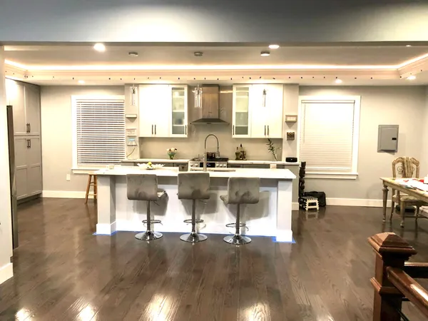 a living room with kitchen island granite countertop furniture a fireplace and wooden floor