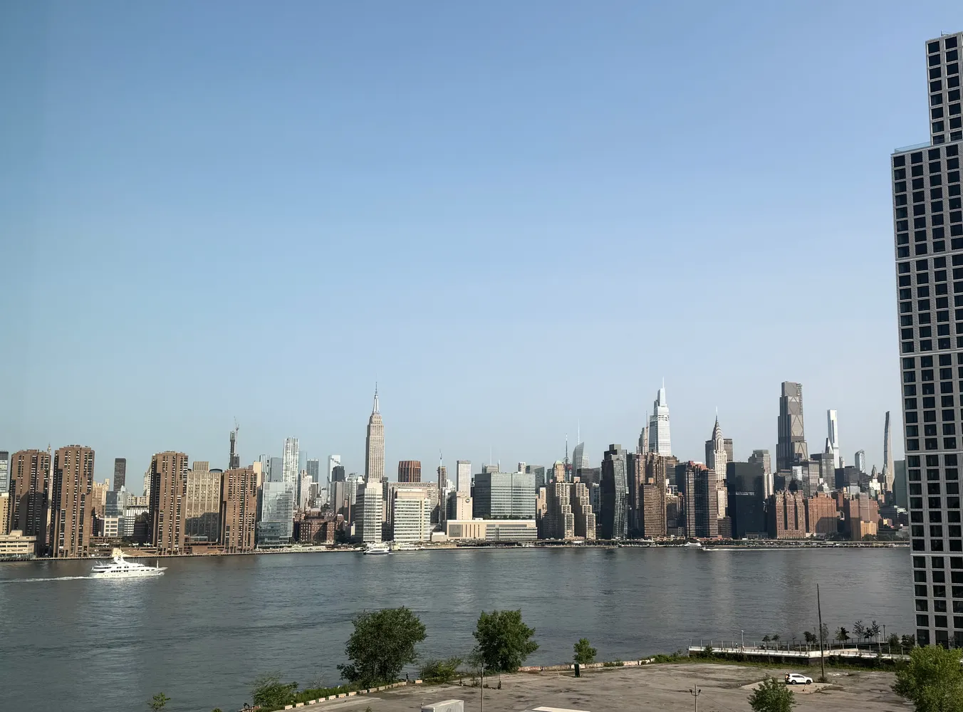 a view of ocean with boats and trees in the background