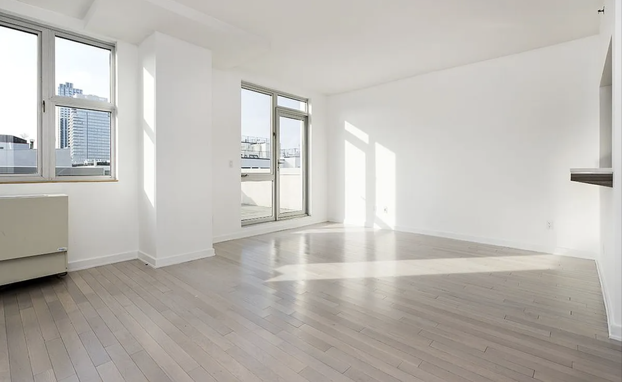 250 Bedford Avenue, Unit 129203 Brooklyn, NY 11249 - Photo 1 of 10 an empty room with wooden floor and windows