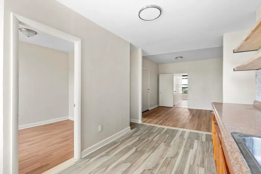 a view of kitchen and hall with wooden floor