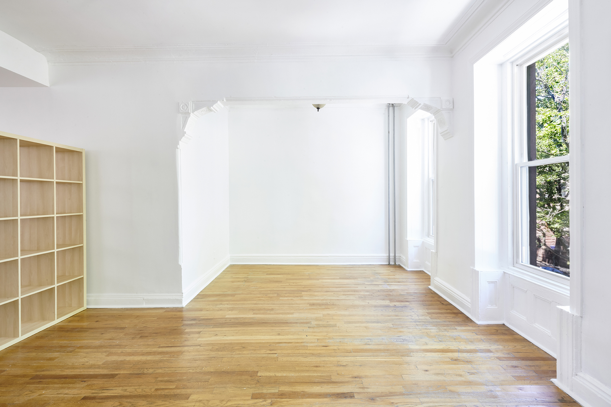 276 Stuyvesant Avenue, Unit 2 Brooklyn, NY 11221 - Photo 6 of 11 a view of an empty room with wooden floor and a window