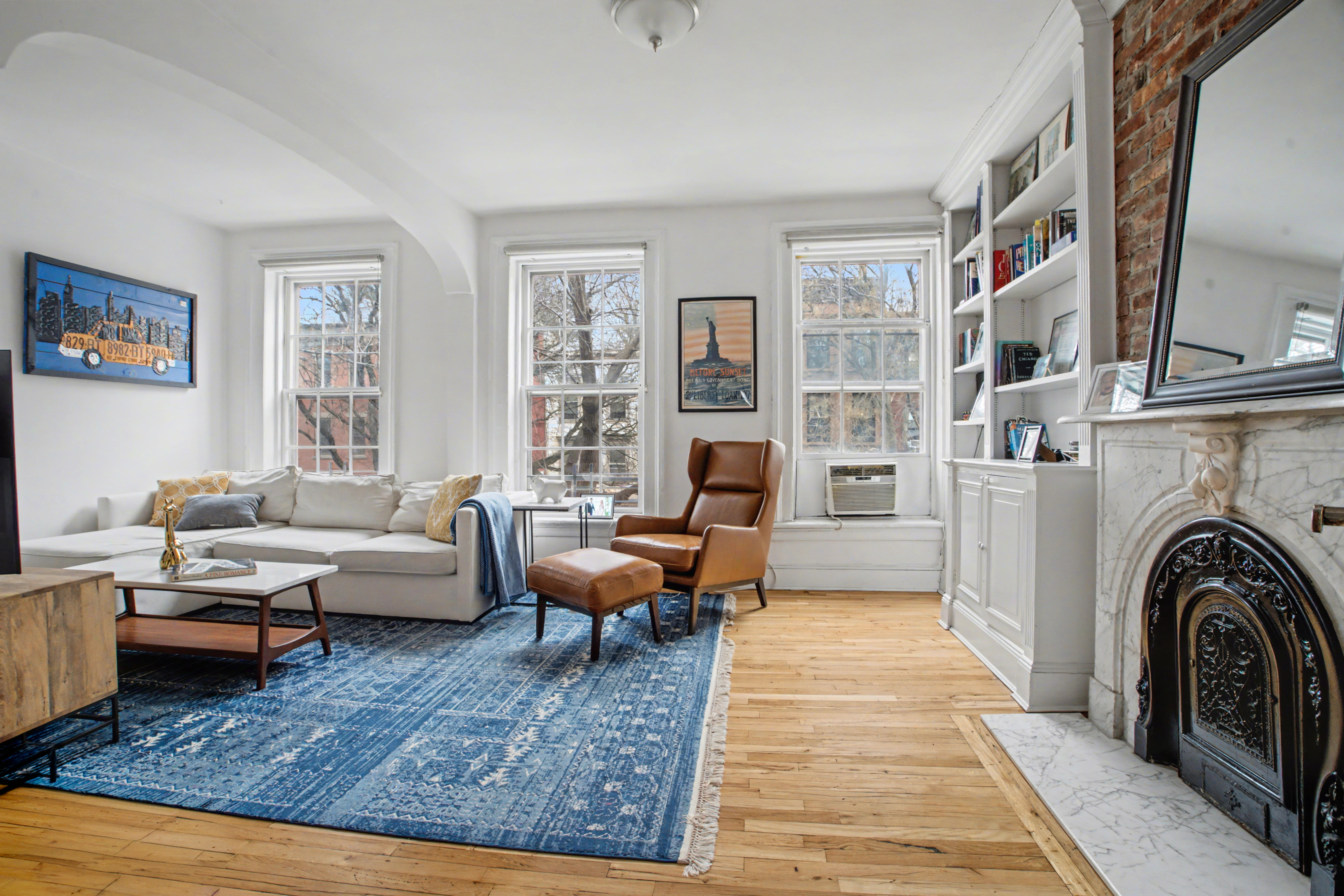 246 Cumberland Street, Unit 2 Brooklyn, NY 11205 - Photo 2 of 15 a living room with furniture large rug and a fireplace