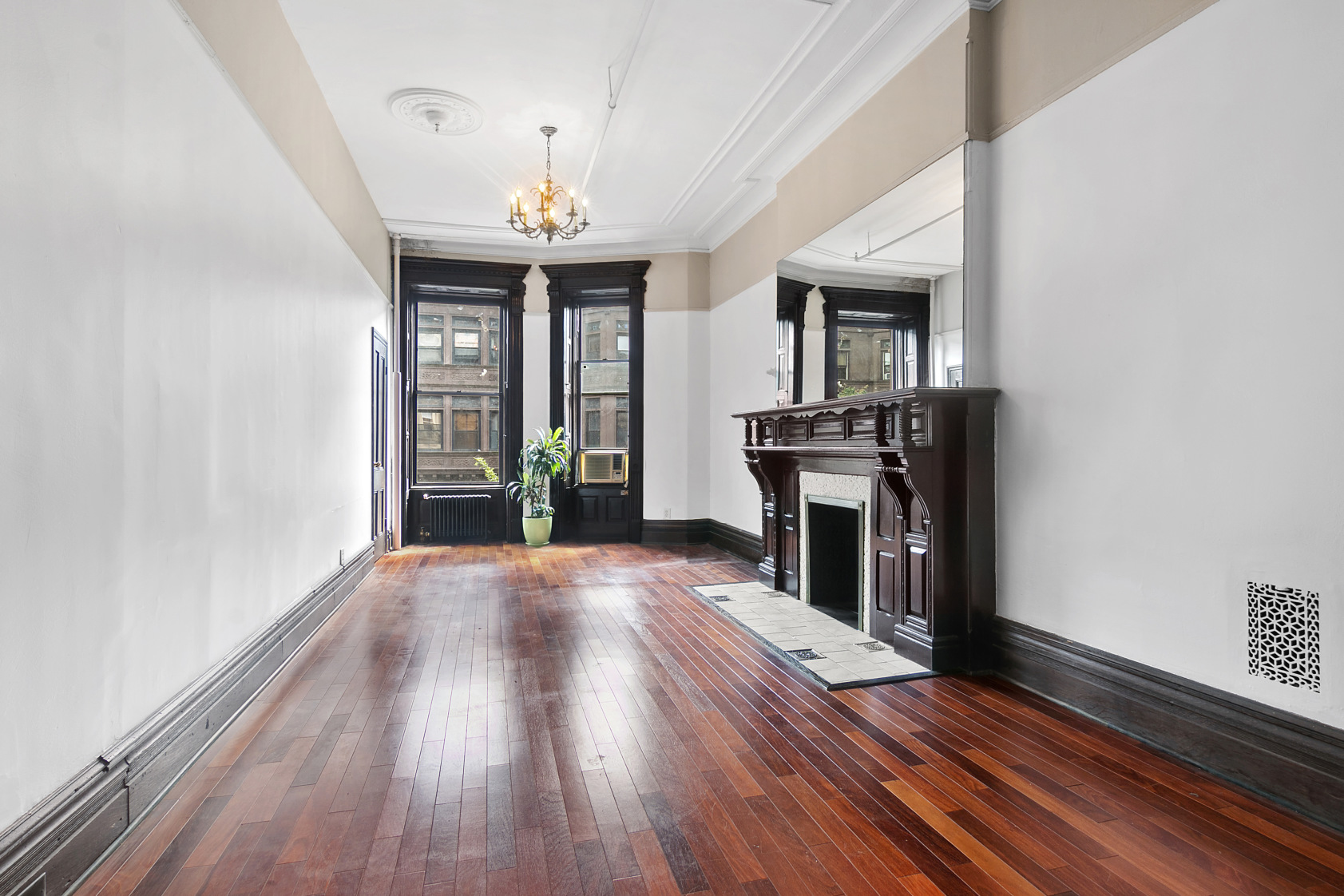 wooden floor fireplace and windows in an empty room