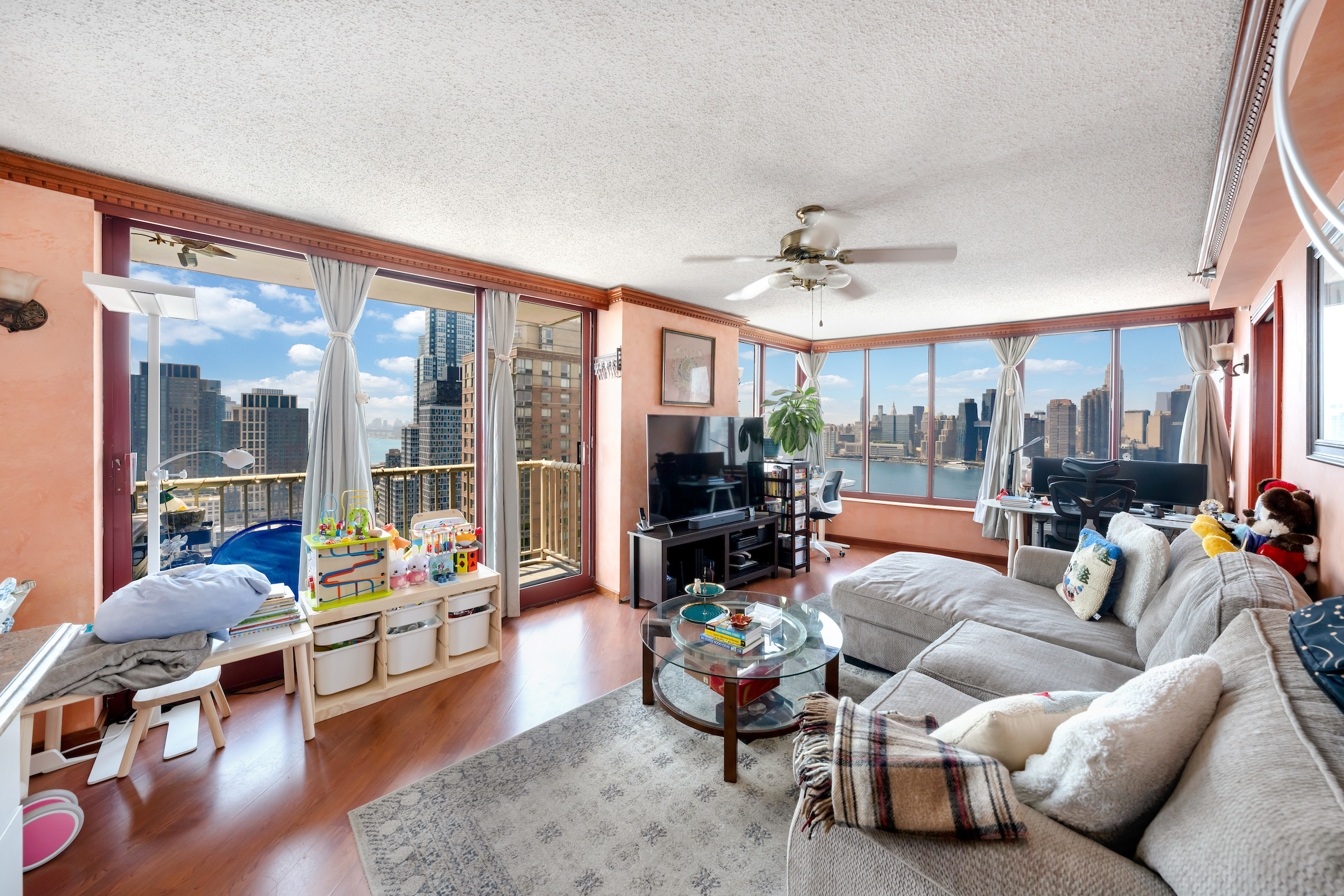 4-74 48th Avenue, Unit 27A Queens, NY 11109 - Photo 4 of 17 a living room with furniture and a large window