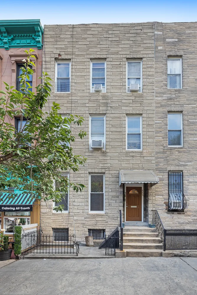 a front view of a brick house with a yard