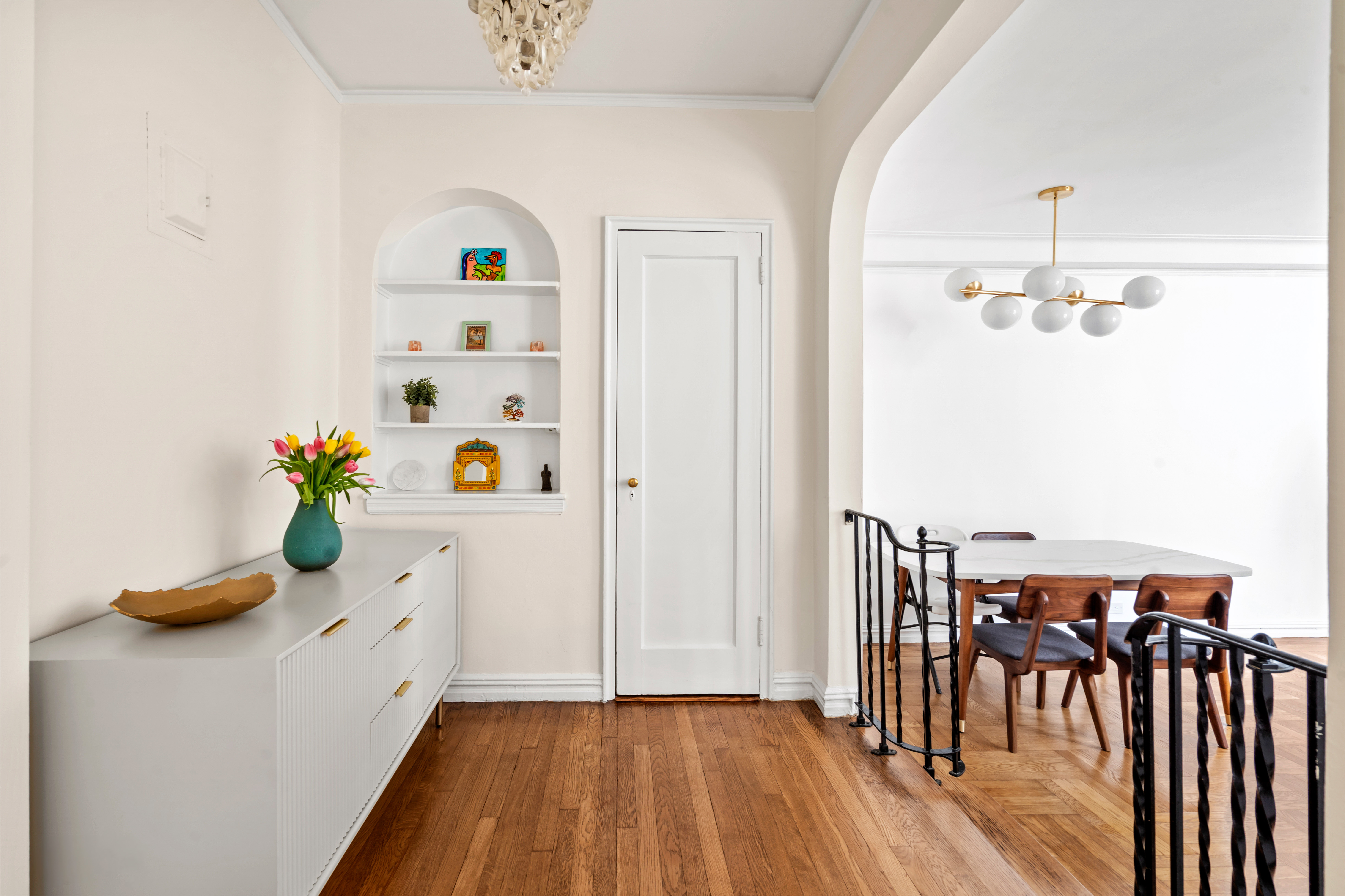 225 West 25th Street, Unit 5D Manhattan, NY 10001 - Photo 3 of 16 a hallway with a dining table chairs and chandelier