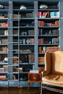 a living room with a book shelf and a book shelf