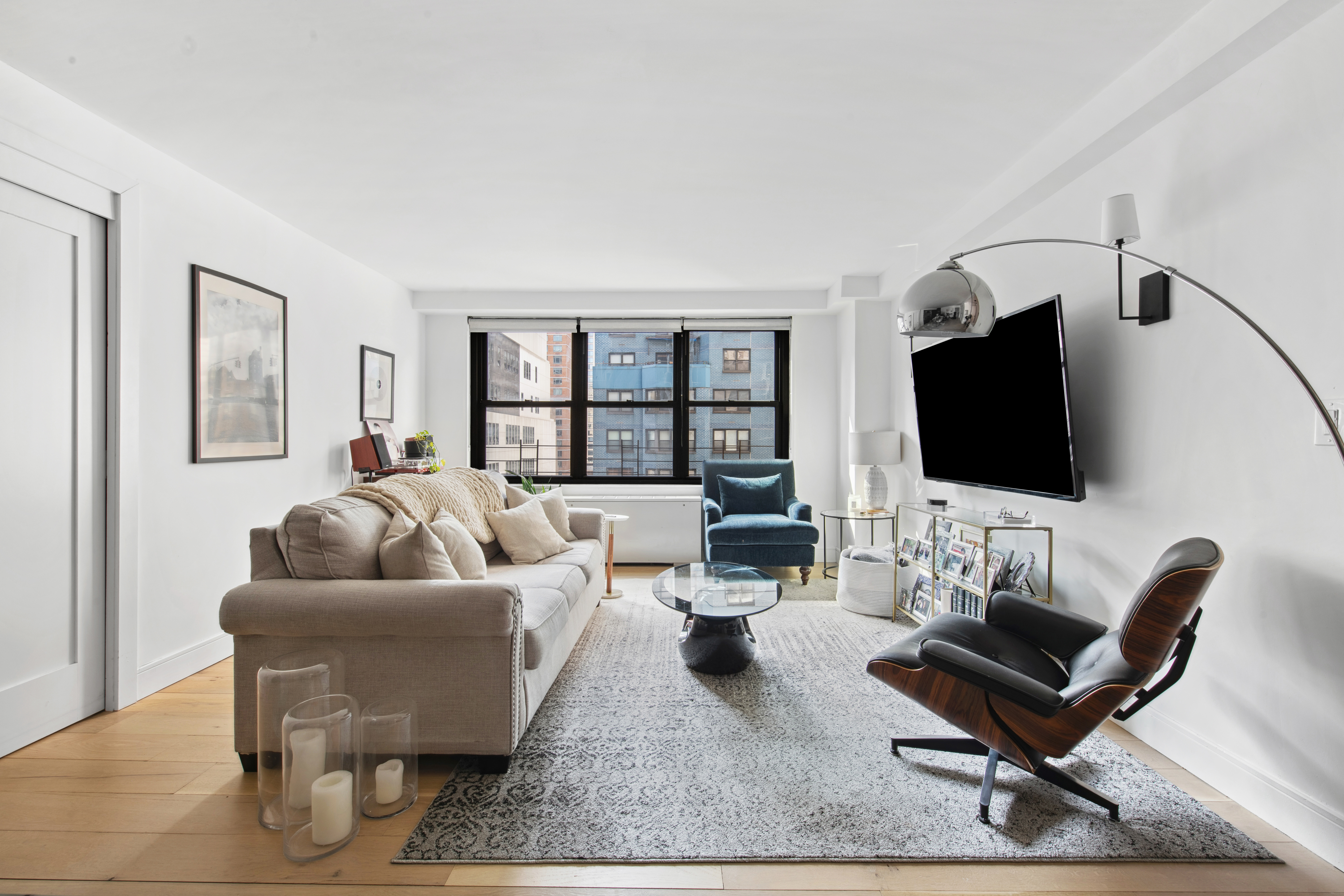 225 East 57th Street, Unit 14E Manhattan, NY 10022 - Photo 2 of 10 a living room with furniture and a flat screen tv