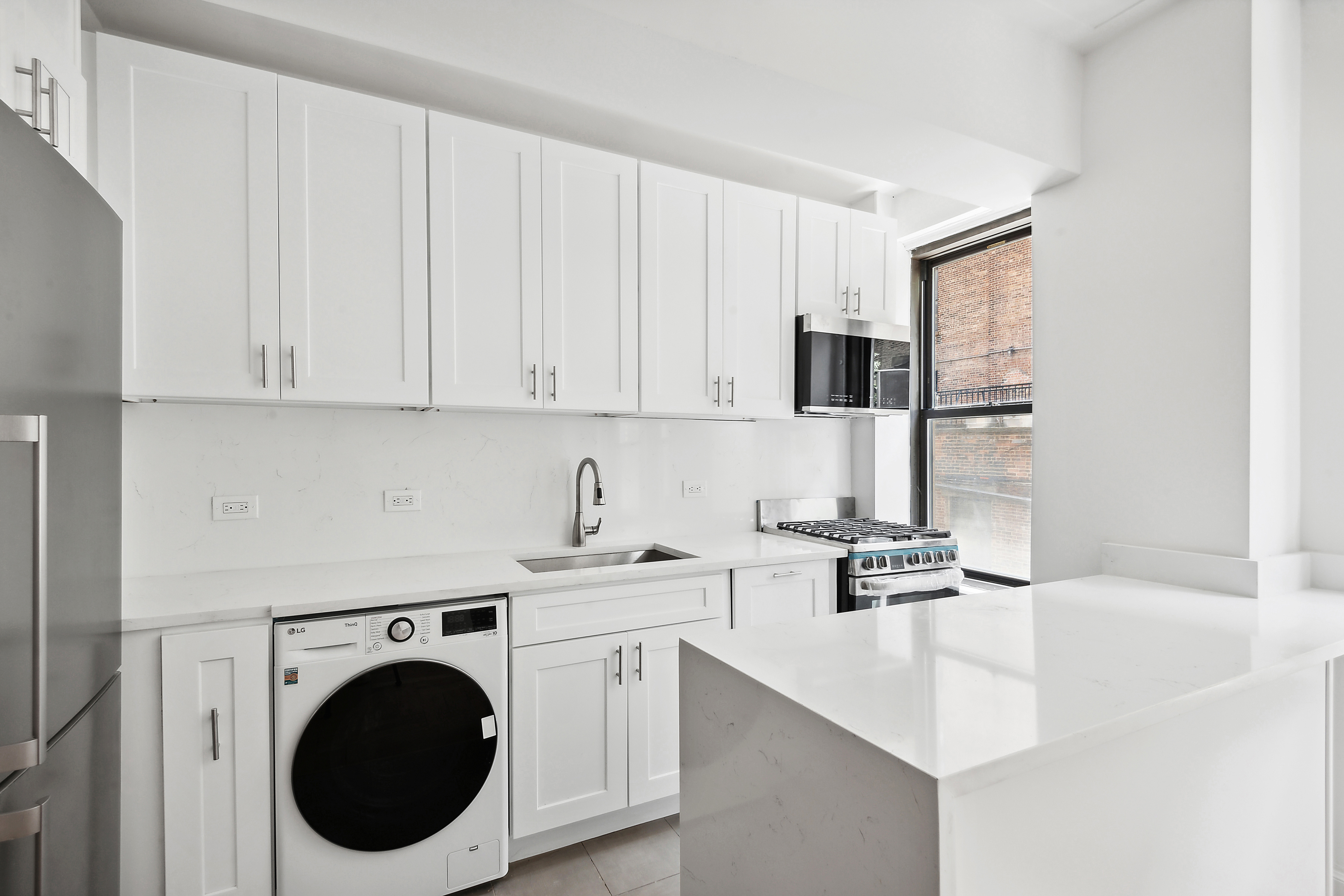 110 West 86th Street, Unit 2D Manhattan, NY 10024 - Photo 2 of 5 a kitchen with a sink cabinets and washing machine