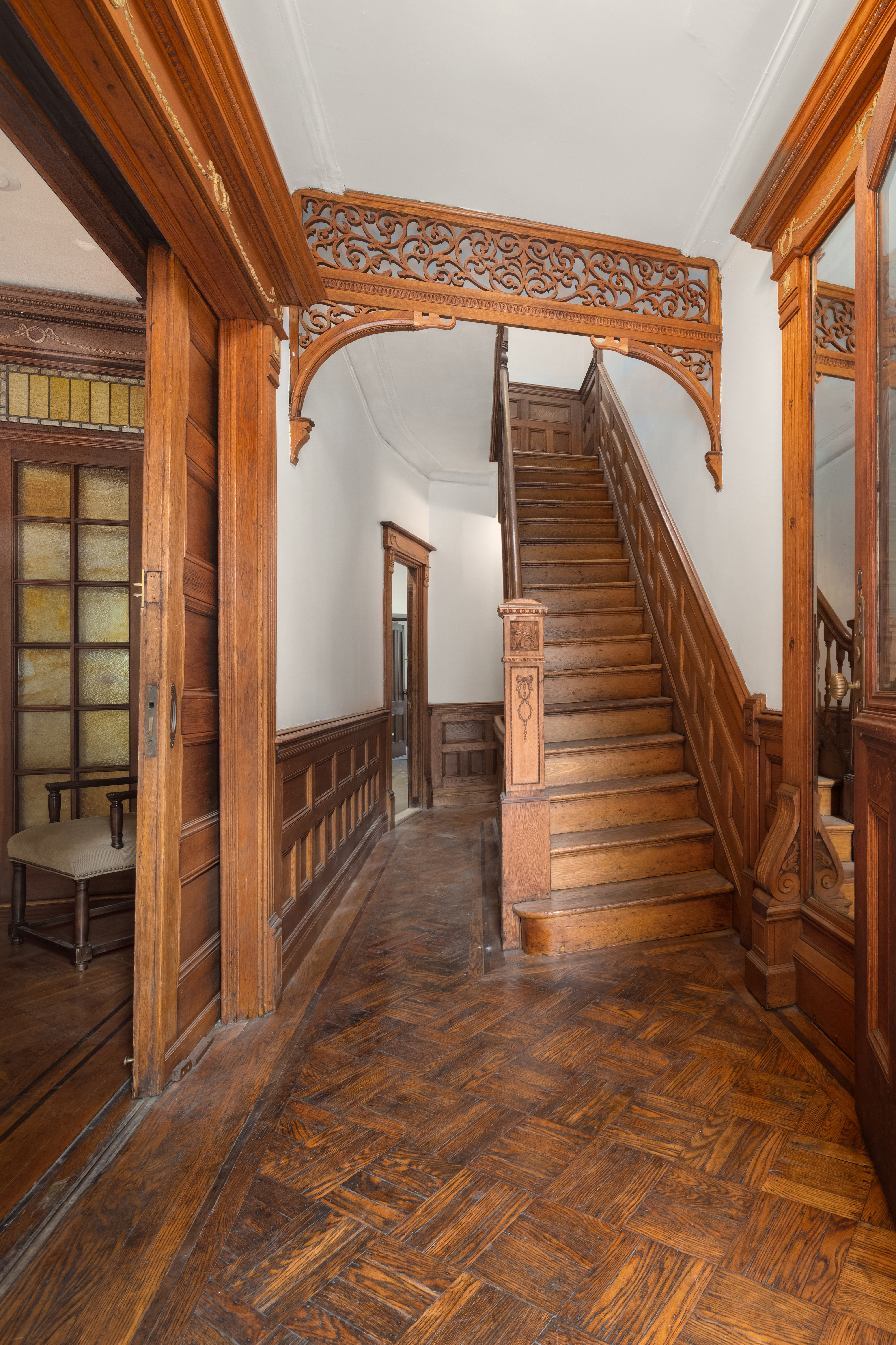 1135 Park Place Brooklyn, NY 11213 - Photo 2 of 18 a view of staircase with lots of frames on wall and a chandelier