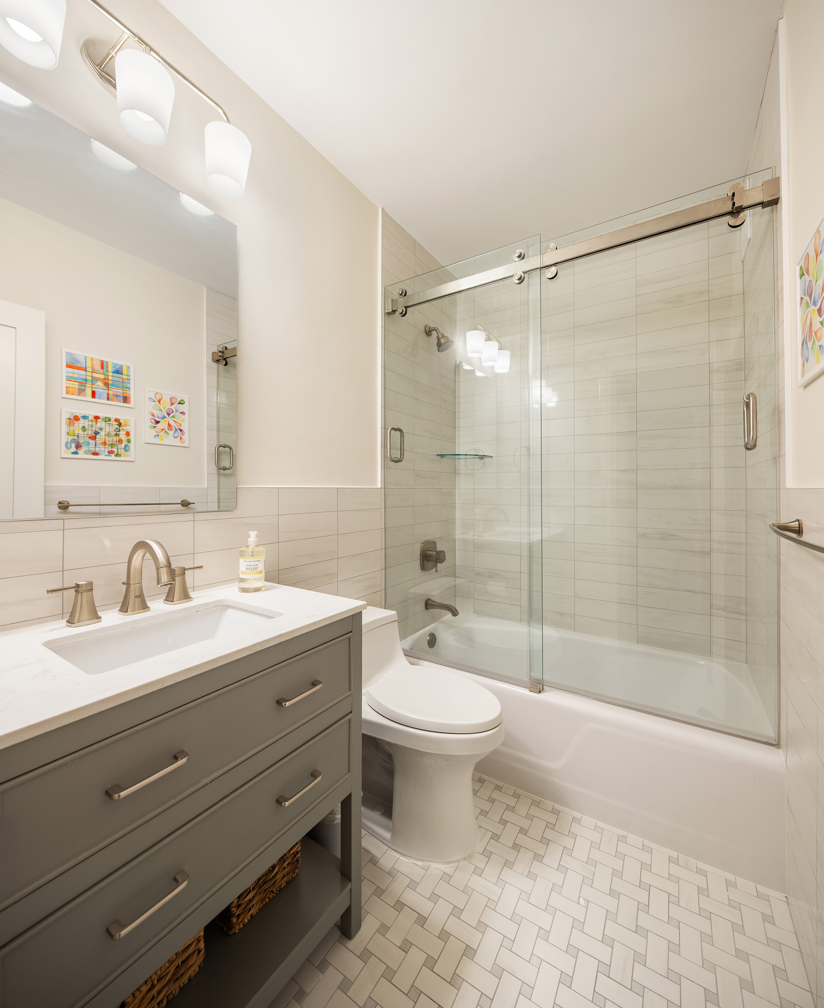135 East 83rd Street, Unit 14B Manhattan, NY 10028 - Photo 10 of 16 a bathroom with a double vanity sink toilet mirror and shower
