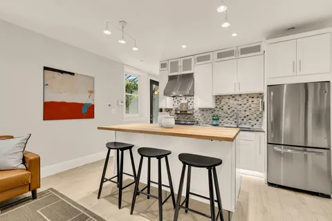 a kitchen with a stove a refrigerator and a dining table