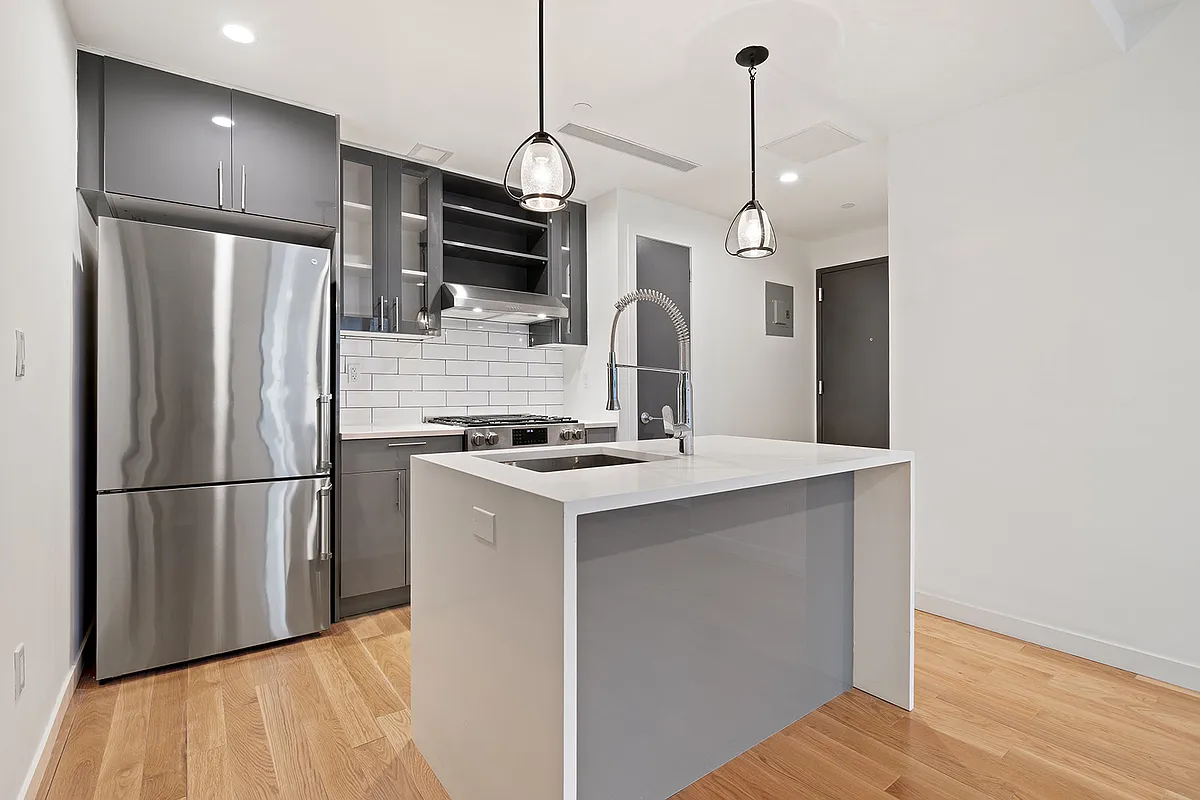 41-21 23rd Street, Unit 6C Queens, NY 11101 - Photo 2 of 10 a kitchen with stainless steel appliances granite countertop a refrigerator a stove and a wooden floors