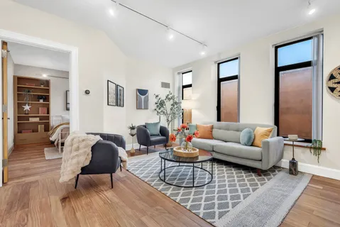 a living room with furniture and wooden floor