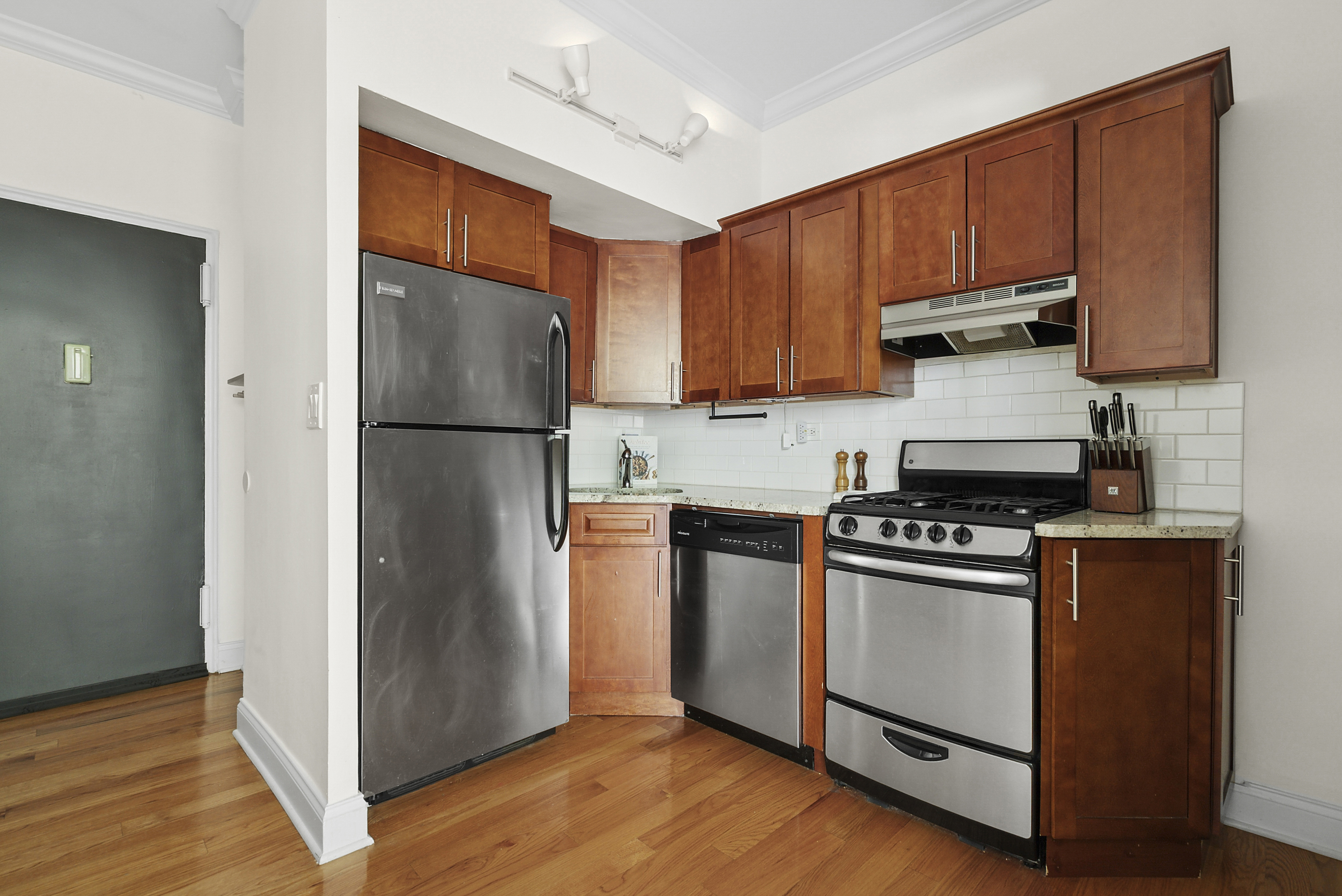 273 Bennett Avenue, Unit 3F Manhattan, NY 10040 - Photo 4 of 9 a kitchen with granite countertop wooden floors and stainless steel appliances