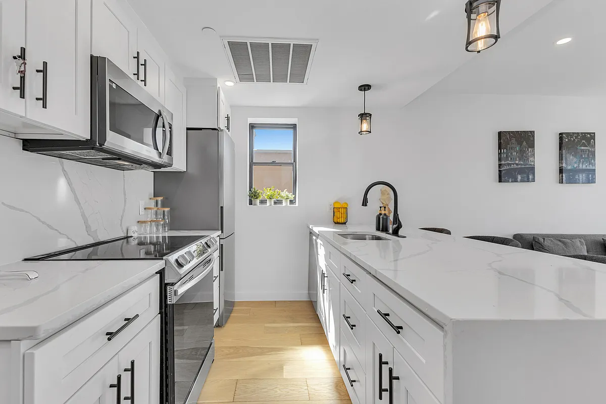 21-10 31st Avenue, Unit 6R Queens, NY 11106 - Photo 3 of 17 a kitchen with stainless steel appliances granite countertop a sink and a stove